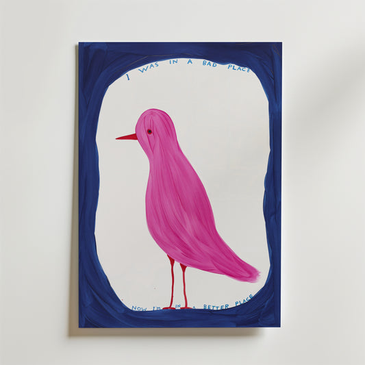Affischen Pink Bird Poster av Bozetto visar en rosa fågel med röd näbb, inramad i blått. Den handskrivna texten ovan lyder "Jag var på en dålig plats" och nedan "Nu är jag på en bättre plats".