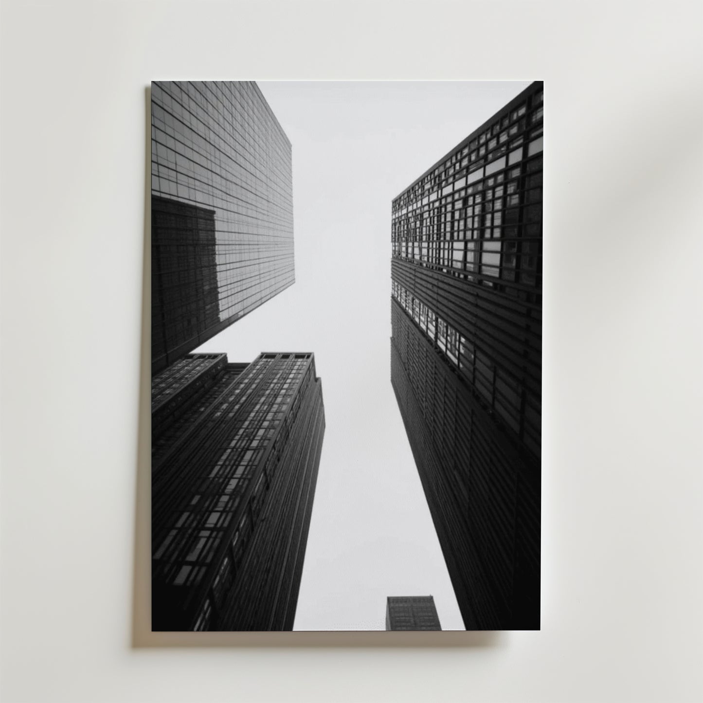 Svartvitt foto av höga skyskrapor taget underifrån med lätta moln ovanför - New York No.2 Poster by Bozetto, tryckt på FSC-certifierat premiumpapper med en lyxig matt finish. Perfekt som väggdekoration med New York som motiv.