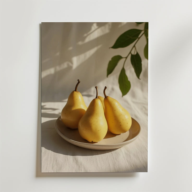 Ett fotografi av tre gula päron på en beige platta, med solljus, skugga och en bladgren - Bozetto's Elegant Pear Poster, tryckt på FSC-certifierat premiumpapper för en högkvalitativ visning.