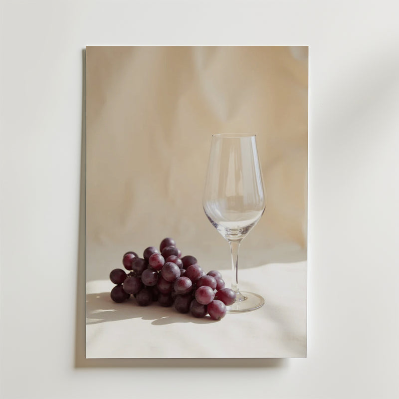 Förhöj din inredning med Bozettos Time For Grapes Poster som visar ett klart vinglas och röda vindruvor på en ljus yta, tryckt på premiumpapper för en elegant touch.