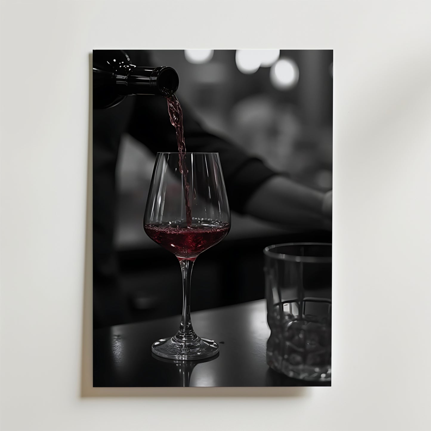 Bozetto Pouring Passion Wine Poster visar rött vin som hälls upp i ett glas på en mörk yta bredvid ett tomt glas, med mjukt suddiga bokeh-ljus som förstärker skönheten i vin i rörelse.