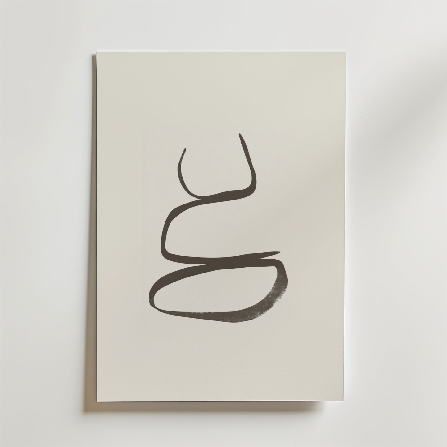 Postern Calm Balance Poster från Bozetto visar ett djärvt, abstrakt svart penseldrag som bildar två slingor på en vit canvas. Affischen är tryckt på premiumpapper och ger harmonisk inredning och elegans till alla utrymmen med sin minimalistiska design.