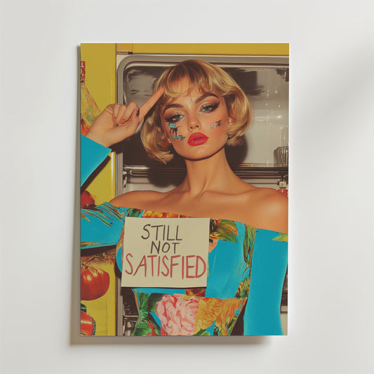 En kvinna med djärvt smink och kort blont hår står vid ett öppet kylskåp i en färgglad outfit, håller i Bozettos "Still Not Satisfied Retro Poster", tryckt på FSC-certifierat premiumpapper med lyxigt matt yta, och pekar mot sitt huvud.