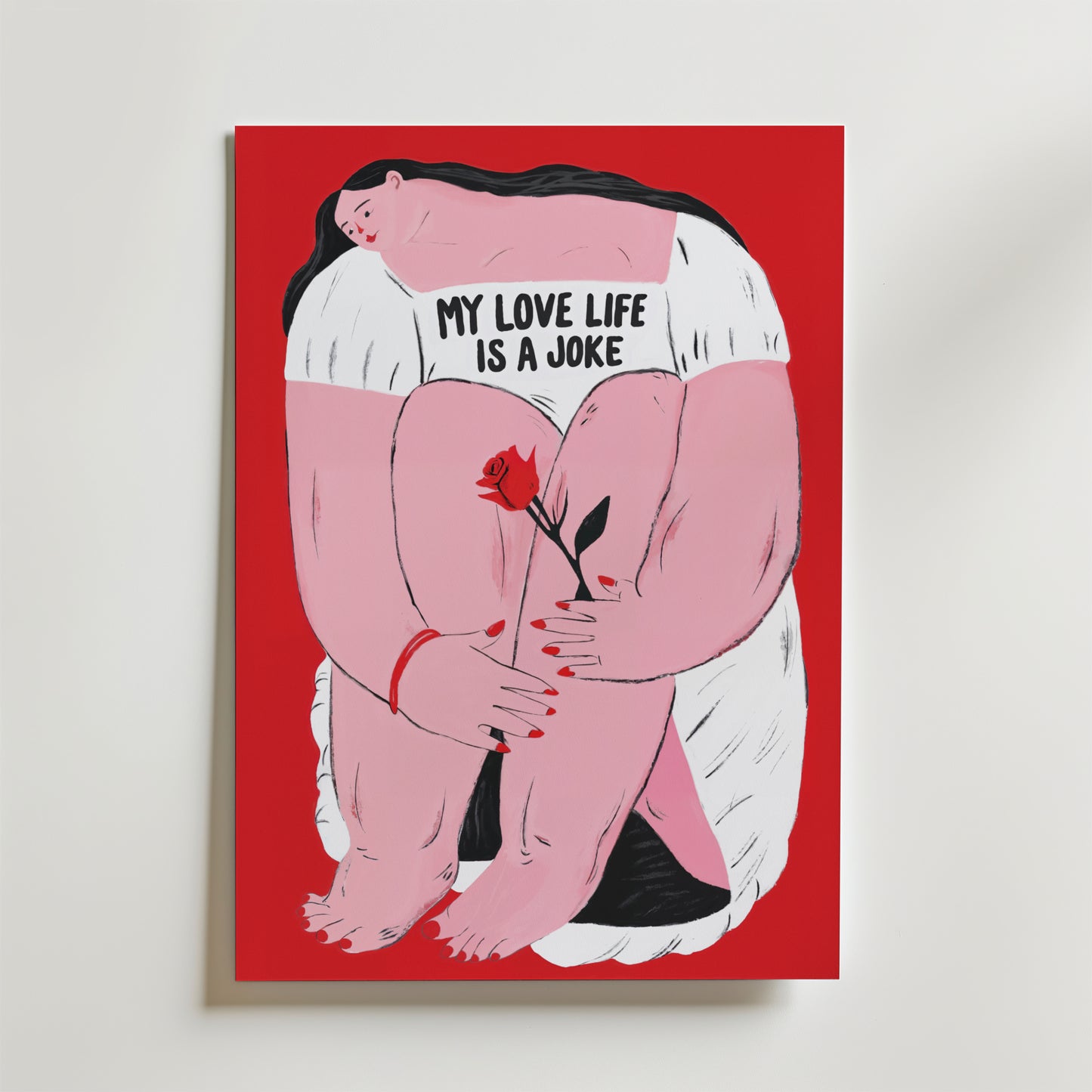 My Love Life Is a Joke Poster från Bozetto föreställer en sittande kvinna med mörkt hår i en vit klänning med texten "My love life is a joke" och en röd ros mot en klarröd bakgrund - perfekt för att skapa humor i alla rum.