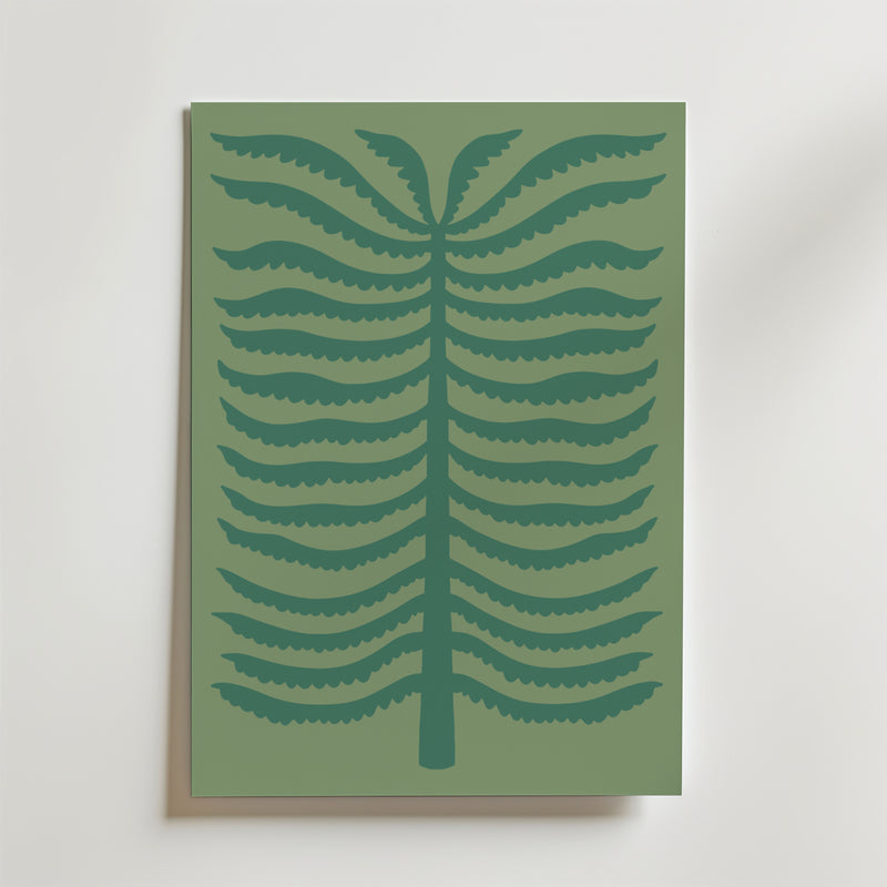 Quiet Palm Poster från Bozetto föreställer en minimalistisk stiliserad ormbunke med mörkgröna symmetriska grenar på en dovt grön bakgrund, inramad och placerad mot en ljus vägg.