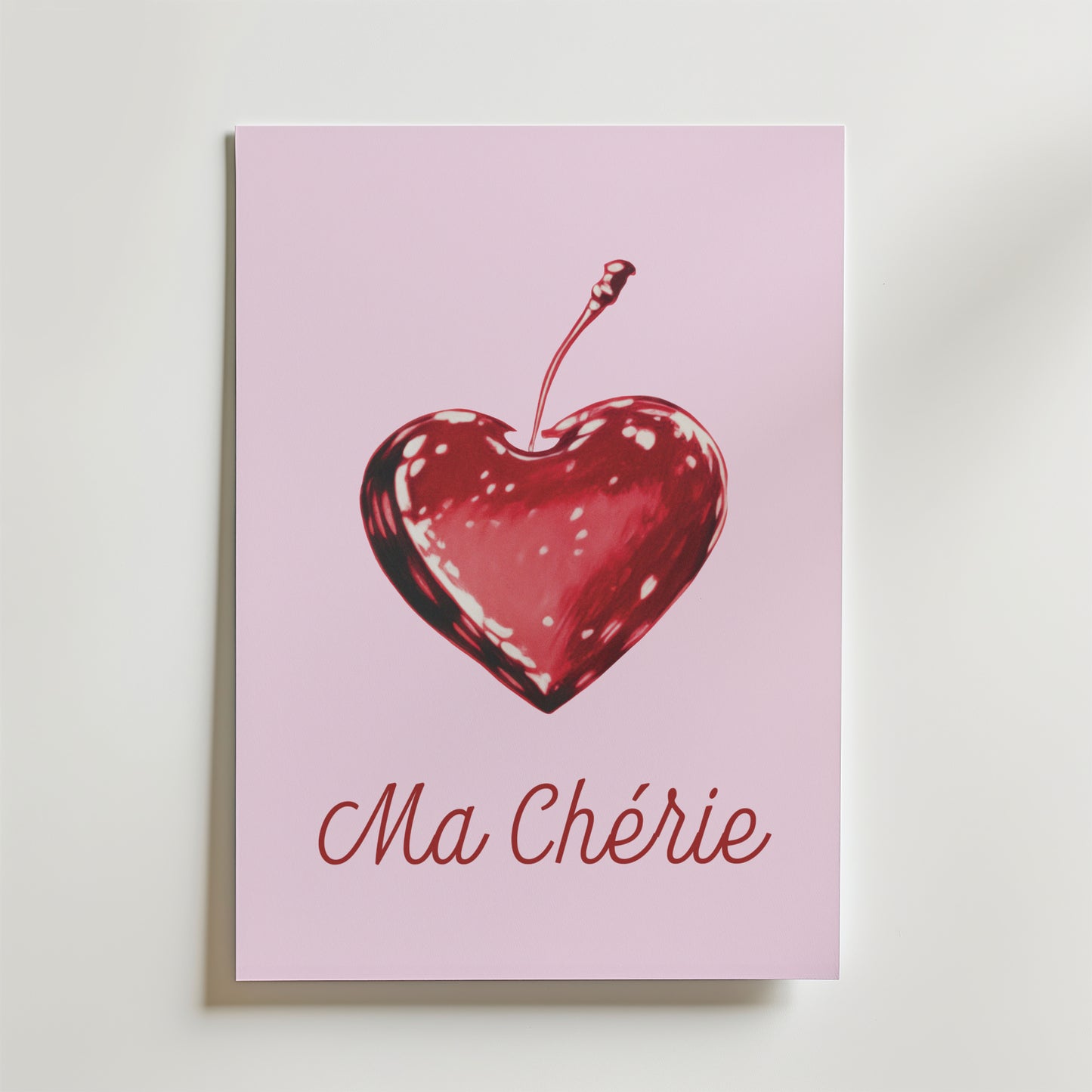 Ma Chérie Cherry Heart Poster från Bozetto har en romantisk design med en hjärtformad körsbärsillustration och "Ma Chérie" i elegant skrift på en ljusrosa bakgrund.
