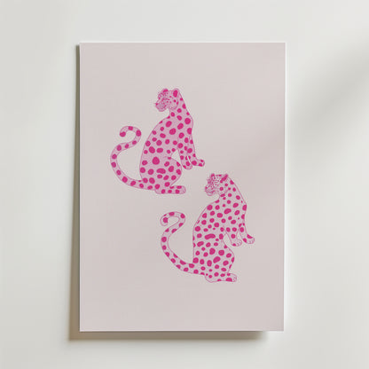 Bozetto Pink Leopard Twins Poster har ett minimalistiskt djurmotiv av två rosa leoparder med mörkare fläckar, som sitter rygg mot rygg på en pastellfärgad bakgrund - perfekt för modern inredning och visas vertikalt på en ljus yta.